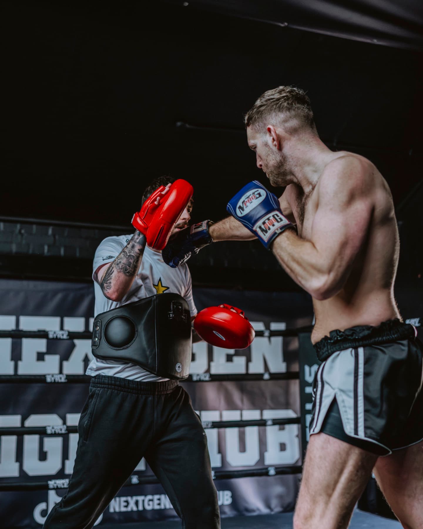 Hayden holding pads for a fighter in the ring at NextGen Fight Hub