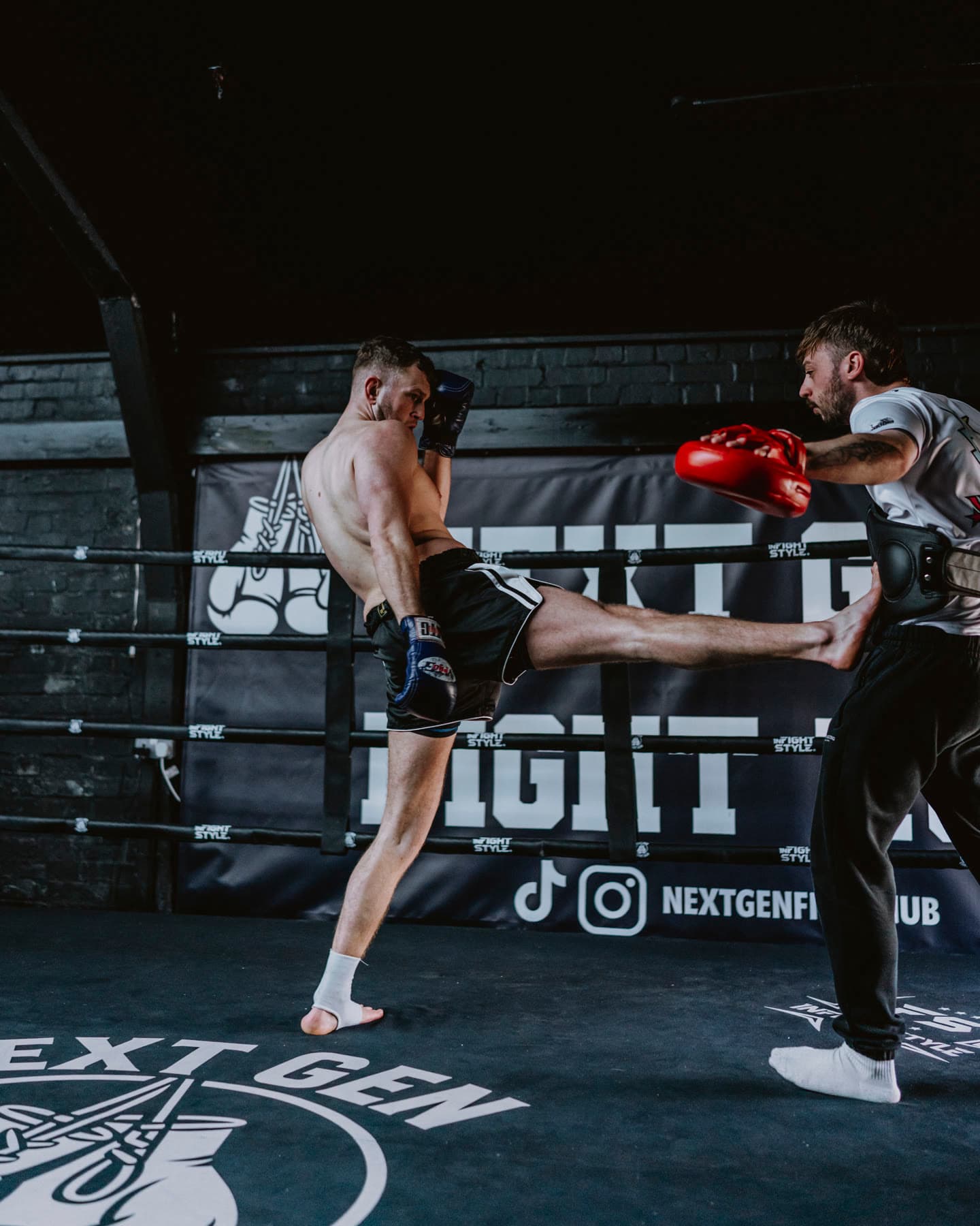 Hayden catching a body kick on the red pads in the ring at Next Gen Fight Hub