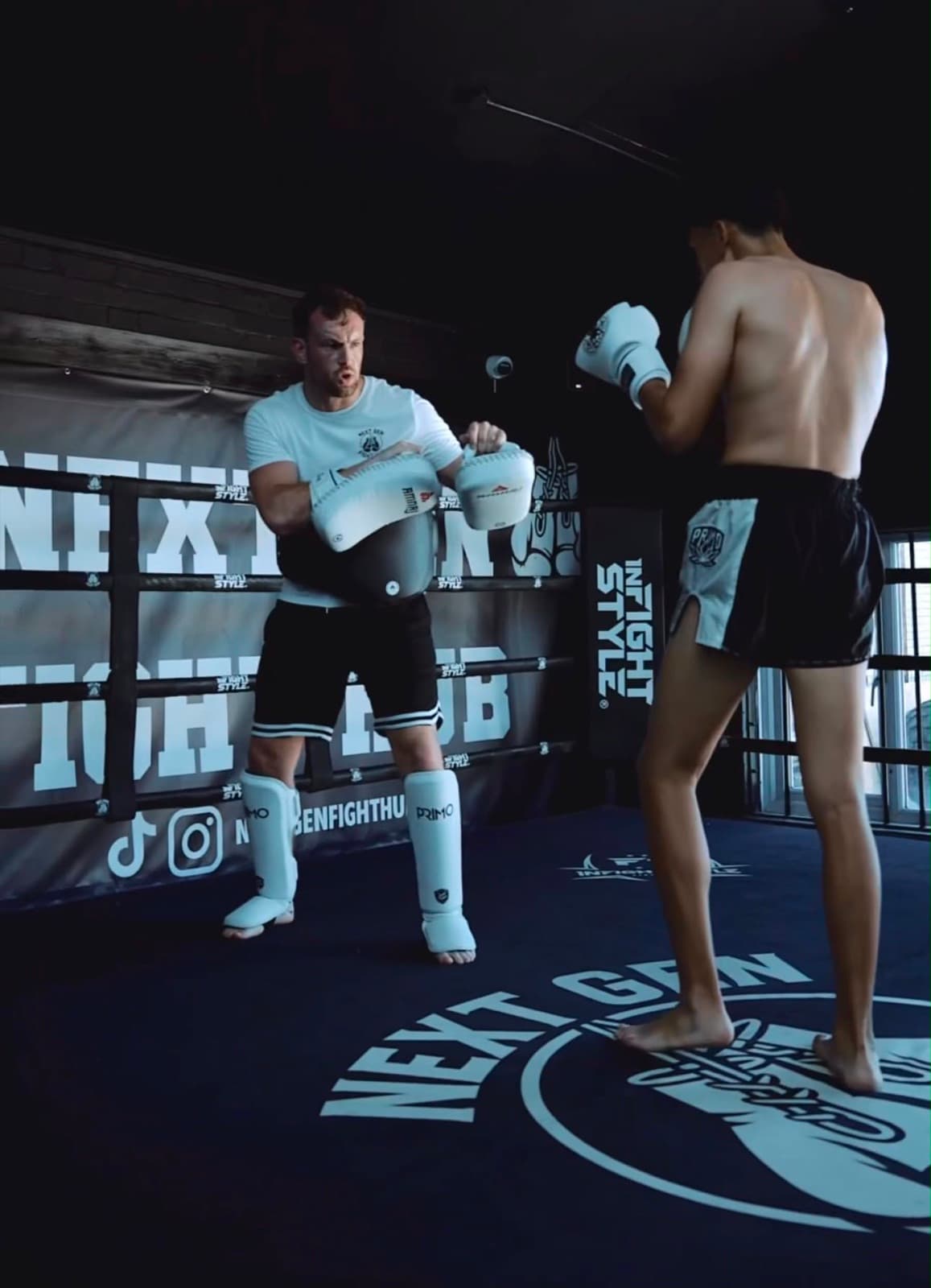 Hayden holding pads for a fighter in the ring at NextGen Fight Hub